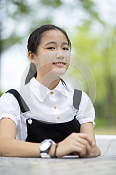 portrait of asian teenager smiling face with green blur background