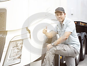 Portrait of Asian a truck driver looking with giving thumb-up and semi truck