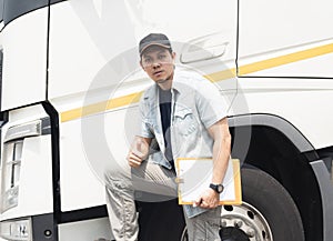 Portrait of Asian a truck driver looking with giving thumb-up and a white truck.