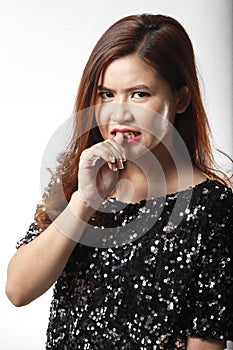 Portrait of Asian woman in Black sequin shirt nip her finger