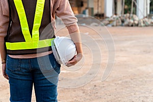Portrait of an Asian woman engineer construction worker wearing a helmet using a tablet while standing at a construction site.