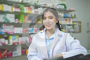 Portrait of asian woman pharmacist wearing lab coat in a modern pharmacy drugstore