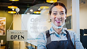 Portrait of Asian woman restaurant or coffee shop owner smile, hanging open sign post. Small business entrepreneur