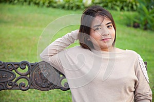 Portrait Asian woman sitting on the bench.