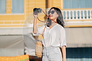 Portrait of asian woman traveler using camera. Asia summer tourism vacation concept
