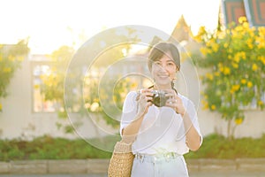 Portrait of asian woman traveler using camera at street of Bangkok, Thailand. Asia summer tourism vacation concept