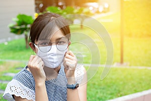 Portrait of Asian woman using surgical mask for protecting COVID-19 or epidemic disease, when go outside