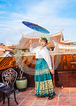 Portrait of asian woman wearing a floral crown and an ancient horse faced skirt