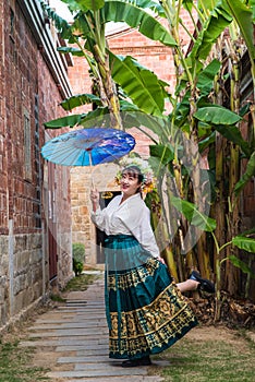 Portrait of asian woman wearing a floral crown and an ancient horse faced skirt