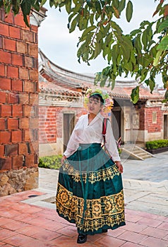 Portrait of asian woman wearing a floral crown and an ancient horse faced skirt