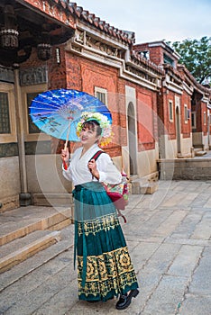 Portrait of asian woman wearing a floral crown and an ancient horse faced skirt