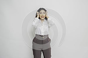 A portrait of an Asian woman wearing a white shirt isolated by white background looks depressed