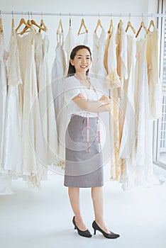 Portrait of asian woman wedding dress store owner standing and cross arm,Beautiful dressmaker in shop and small business,Happy and