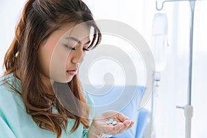 Portrait of Asian young beautiful woman patient eating pill or drug with isolated white background