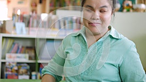 Portrait of Asian young blind person woman reading Braille book studying in creative library