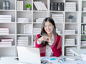 Portrait of an Asian young business Female working on a laptop computer in her workstation.