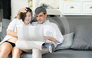 Portrait of a asian young couple husband and wife sitting on the sofa.