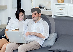 Portrait of a asian young couple husband and wife sitting on the sofa.