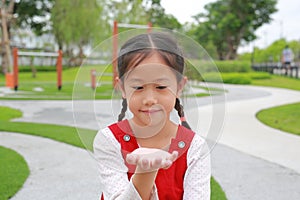 Portrait Asian young girl show expression hand holding something while in the garden