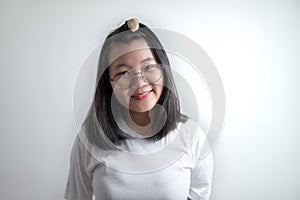 Portrait of Asian young pretty girl with her eyes glasses and white casual t-shirt in studio light clear white background