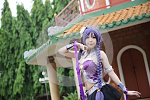 Portrait of asian young woman dancing with purple Chinese dress cosplay with temple