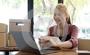 Portrait of Asian young woman SME working with a box at home the workplace.start-up small business owner, small business