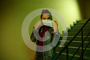 Portrait of an Asian young woman. stairwell of the hospital. the girl wears a mask to avoid getting infected with the virus