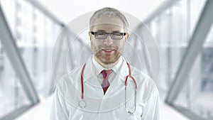 Portrait of assuring doctor in modern hospital glass hallway. Shot on Red camera