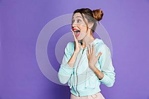 Portrait of astonished attractive woman with two buns holding ha