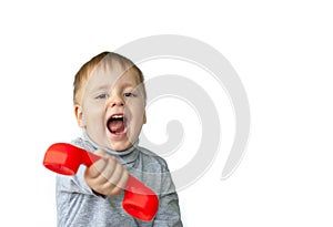Portrait of an astonished cute little boy holding a red telephone receiver.