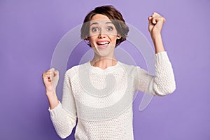 Portrait of astonished person fists up open mouth scream yeah won lottery isolated on purple color background