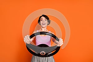 Portrait of astonished positive girl hold steering wheel imagine she ride fast speed car wear stylish tank-top checkered