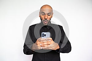 Portrait of astounded young man reading message on mobile phone