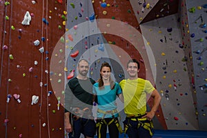 Portrait of athletes standing by climbing wall in health club