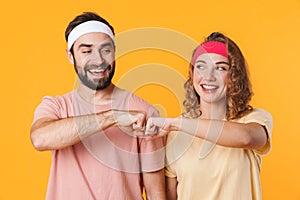 Portrait of athletic couple smiling and bumping their fists together