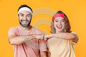 Portrait of athletic couple smiling and bumping their fists together