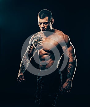 Portrait of athletic male bodybuilder isolated on black background.