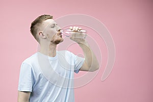 Portrait of athletic man drinking clean water from a bottle after training.