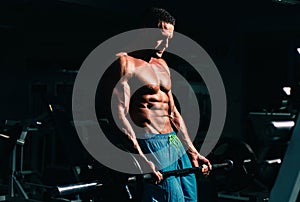 Sport man doing biceps lifting barbell. Portrait of athletic man without a shirt with dumbbells. Shirtless man man with