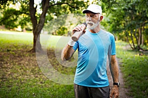 Portrait of athletic mature man after run. Handsome senior man resting after jog at the park