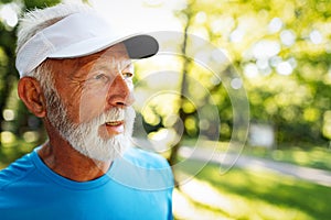 Portrait of athletic mature man after run. Handsome senior man resting after jog at the park