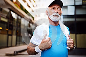 Portrait of athletic mature man after run. Handsome senior man resting after jog at the park