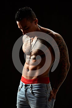 Portrait of athletic young tattooed guy. Studio shot, isolated