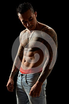 Portrait of athletic young tattooed guy. Studio shot, isolated