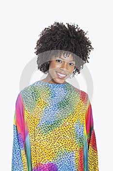 Portrait of an attractive African American woman in multicolored dashiki standing over gray background