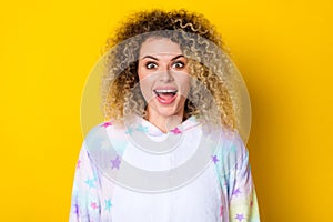 Portrait of attractive amazed cheerful girly wavy-haired girl in pajama good mood  over bright yellow color