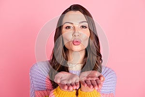 Portrait of attractive amorous brown-haired girl sending you air kiss coquette isolated over pink pastel color