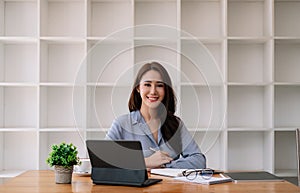 Portrait Attractive Asian Businesswoman working with smart tablet on wooden desk at her office