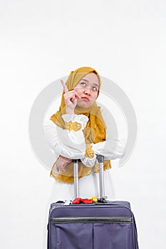 Portrait of attractive asian muslim woman on white dress with hijab bring purple suitcase isolated over white background