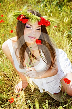 Portrait of an attractive beautiful girl in a poppy field